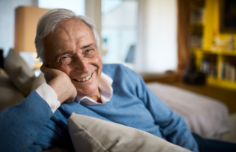 Man in Blue Sweater Smiling and Relaxing on Couch